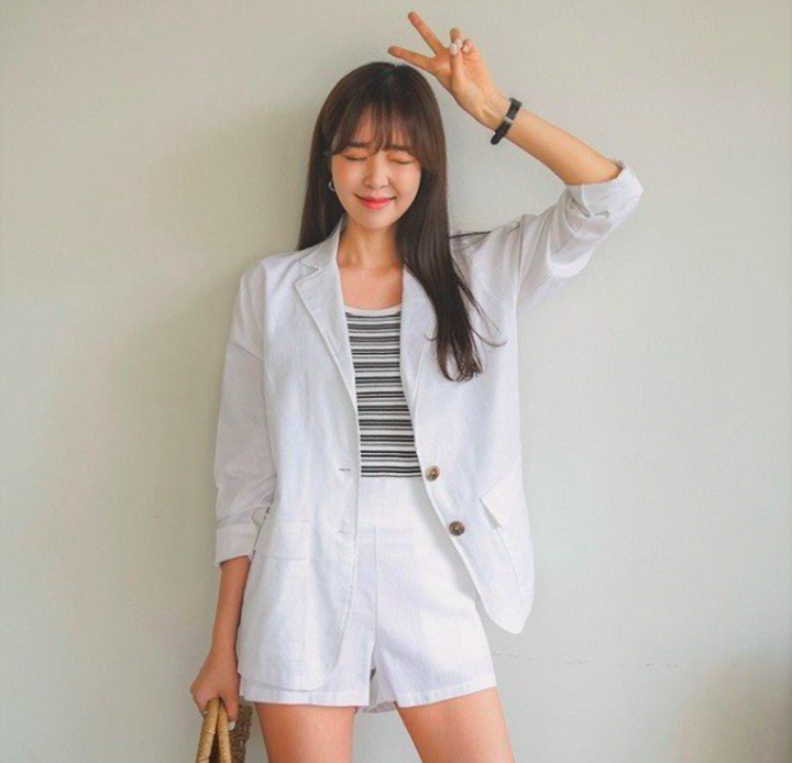 Quần shorts trắng và áo blazer tạo nên phong cách thời trang năng động, thanh lịch.