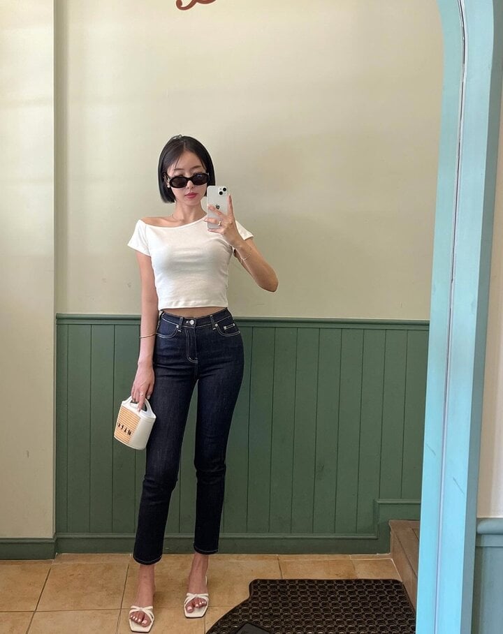 Áo thun trắng và quần skinny jeans không quá cầu kỳ nhưng vẫn rất nổi bật. Bộ trang phục tôn dáng rất hiệu quả nhờ thiết kế áo lửng, quần ôm sát.